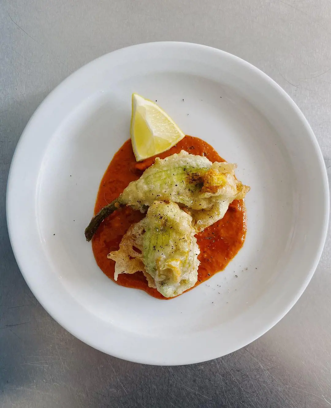 Battered courgette flowers stuffed with ricotta, served with salmorejo