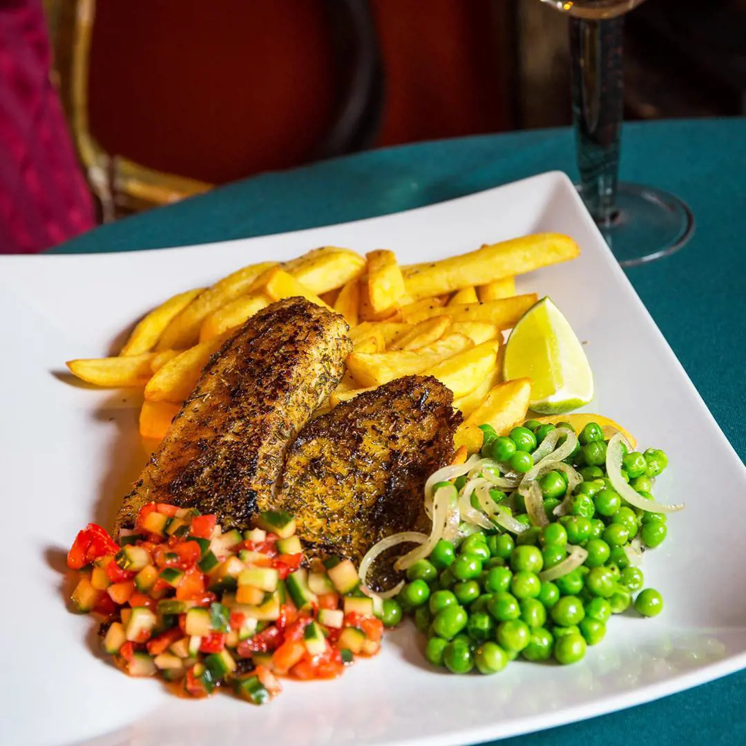 Fish and chips with a twist - Black tilapia, sauteed peas, strawberries, cucumber salsa and chips