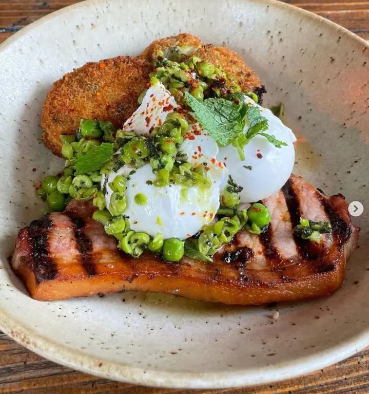 Bacon chop, bubble and squeak fritters, poached eggs, minted pea salsa, aleppo chilli⁠