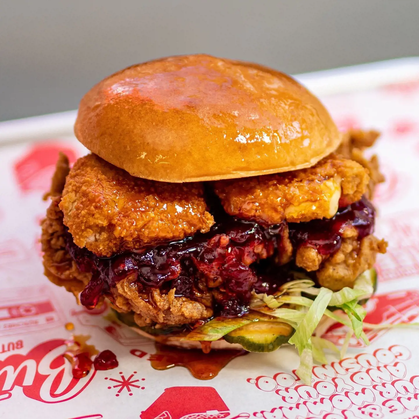Decadent burger of buttermilk fried chicken with melted brie and cranberry