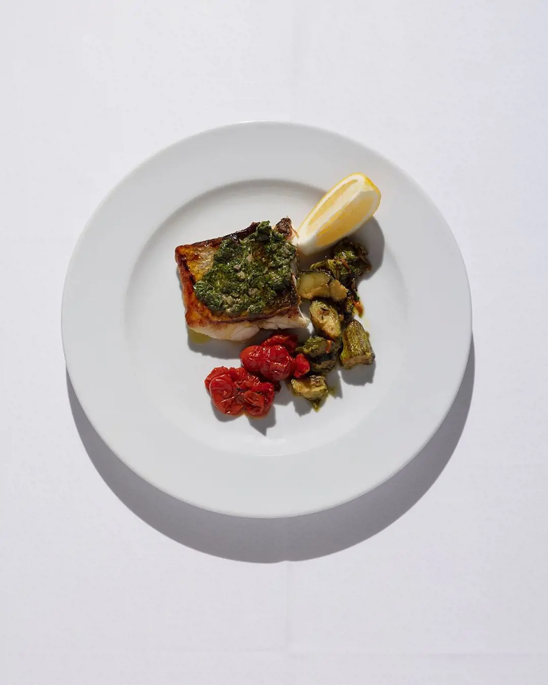 Sea Bass fillet with Roman Zucchini Trifolati, Roast Datterini Tomatoes and Salsa Verde